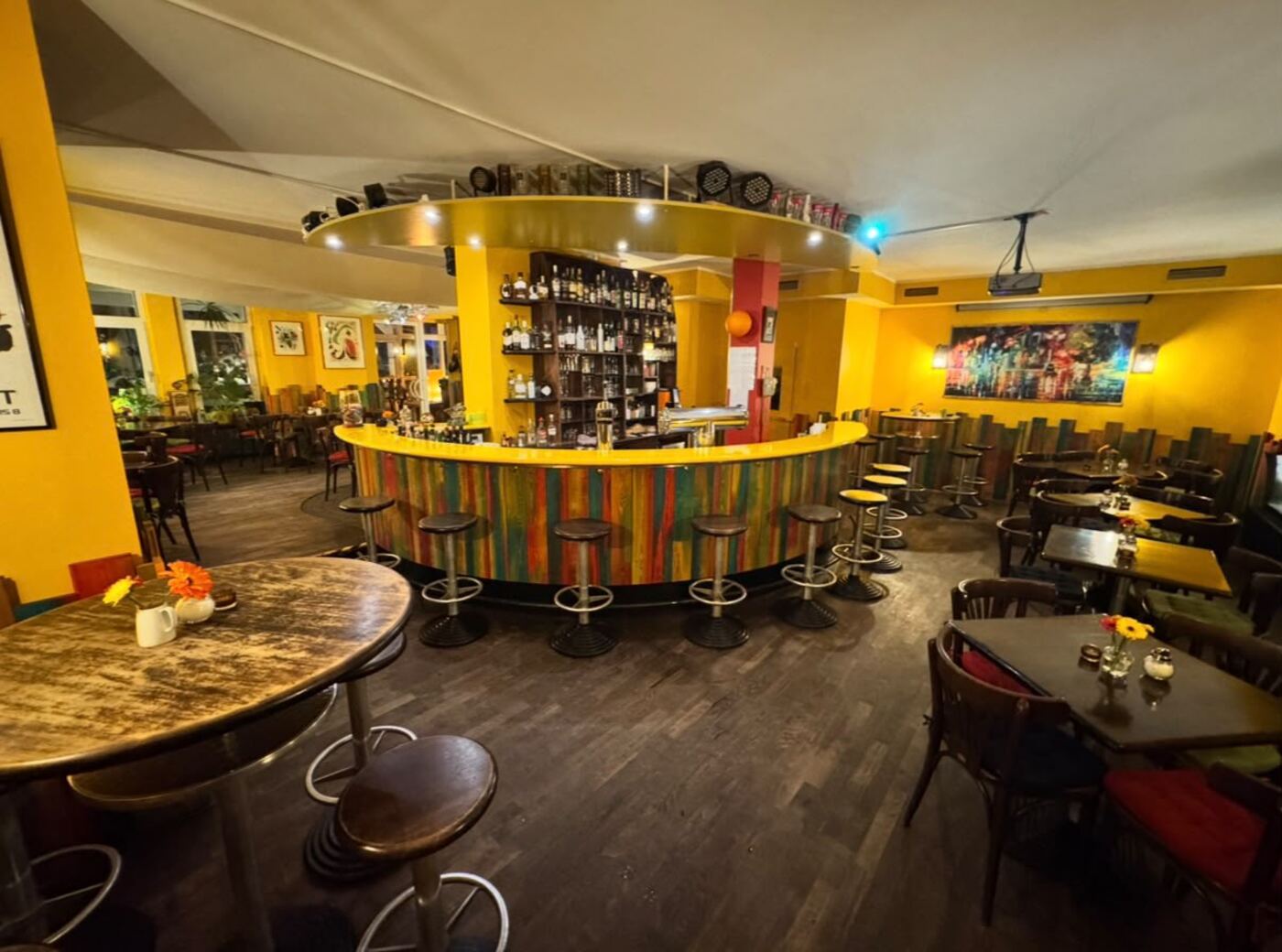 Gastraum des zum Verkauf stehenden Restaurants mit Bestuhlung, Stehtischen und Thekenanlage